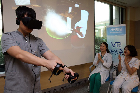 서울아산병원 직원이 VR기술을 적용한 교육과정에서 화재를 진압하는 체험을 하고 있다.   서울아산병원 제공